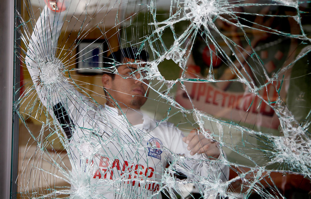 A worker of a fast food restaurant stands behind a storefront window